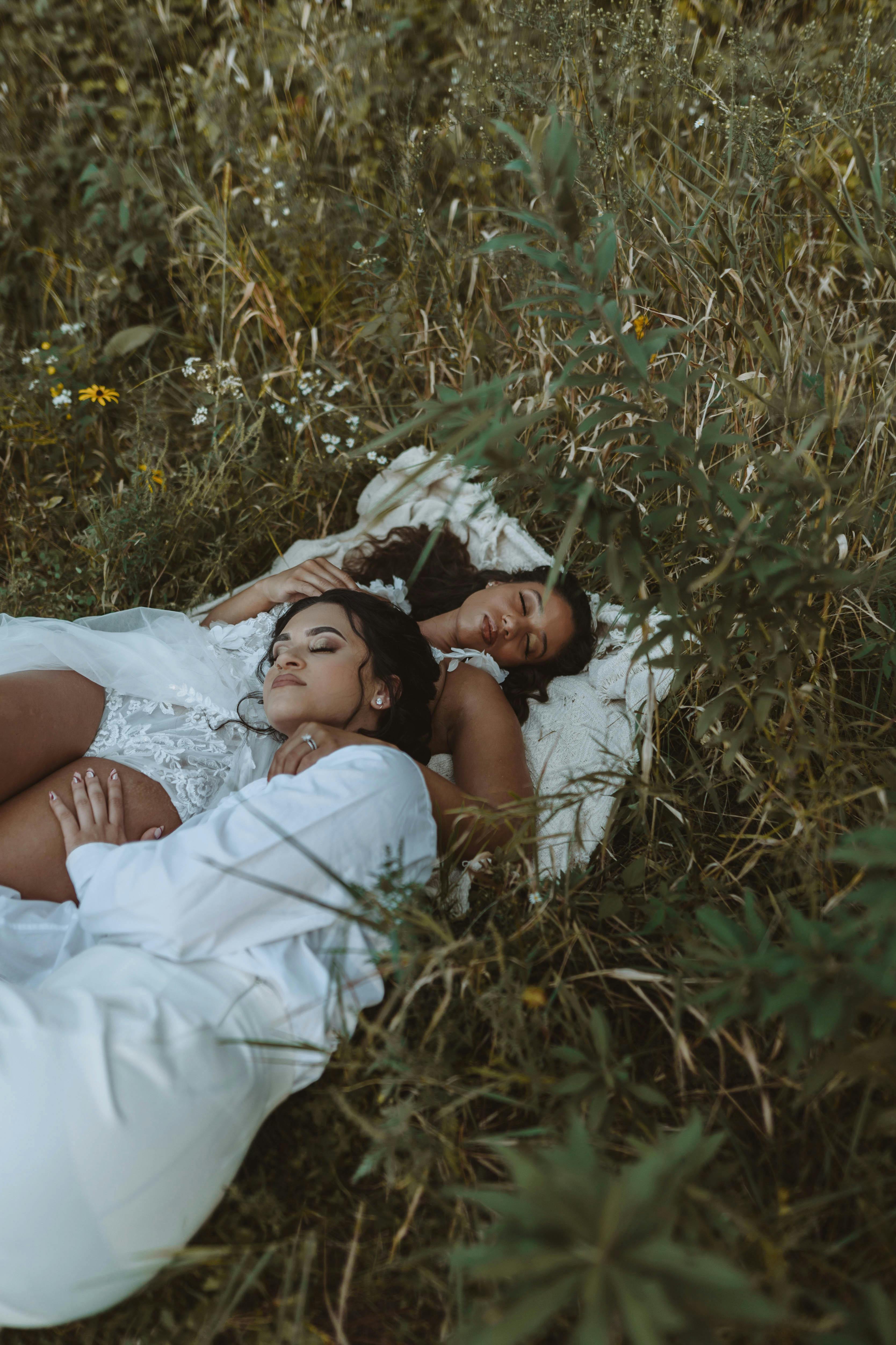 women laying in grass